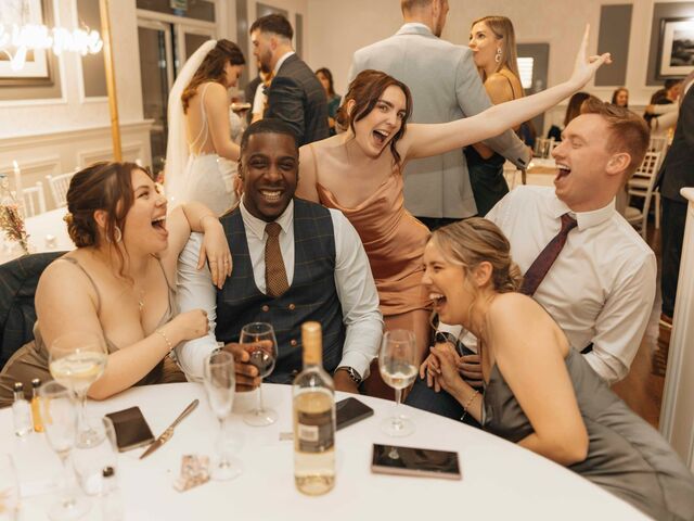 Wedding guests laughing around a reception table